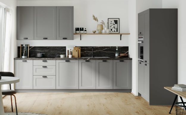 Bild einer kleinen Landhausküche in grau mit Arbeitsplatte in dunklem Marmor